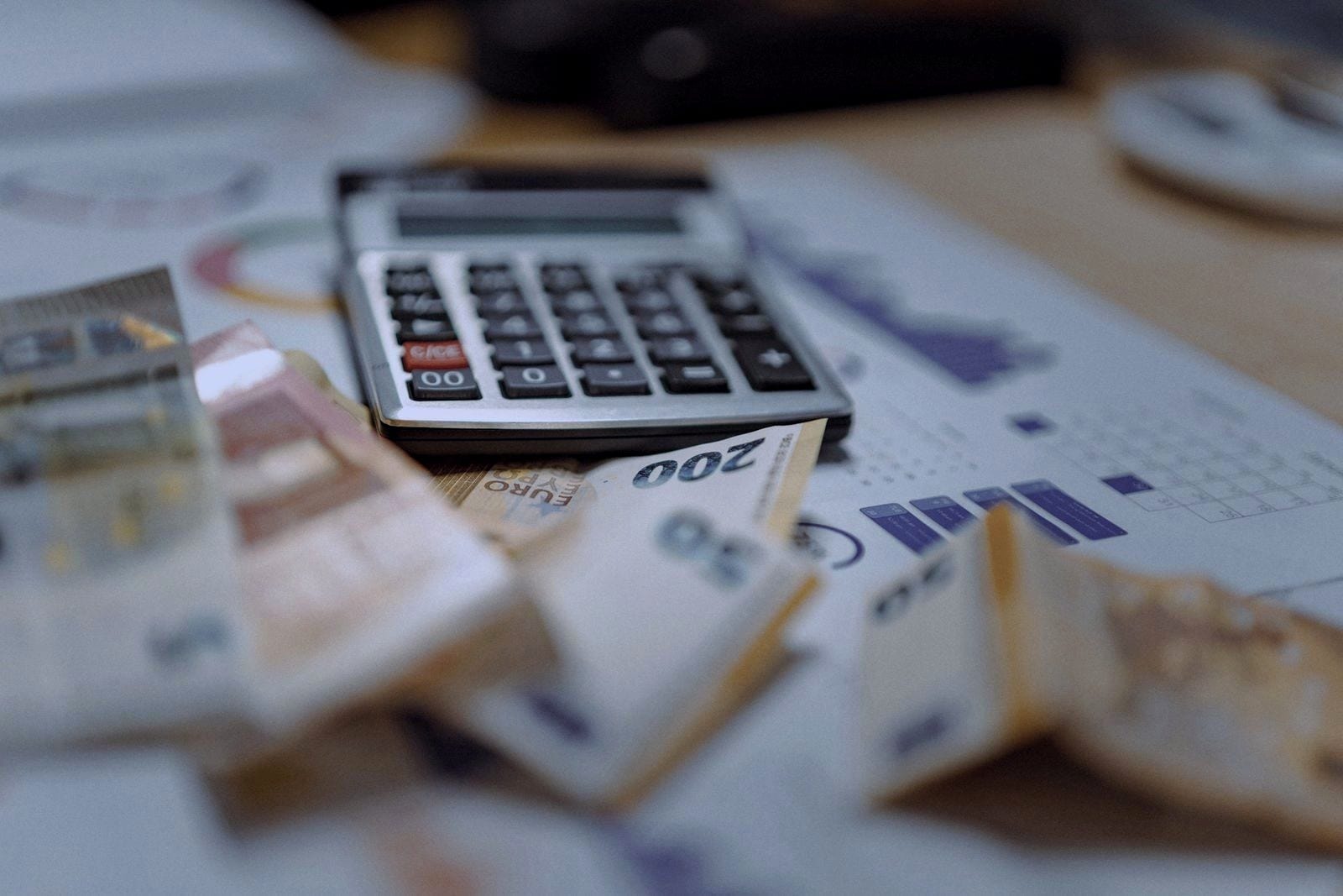 Calculadora sobre billetes de euro y gráficos impresos.